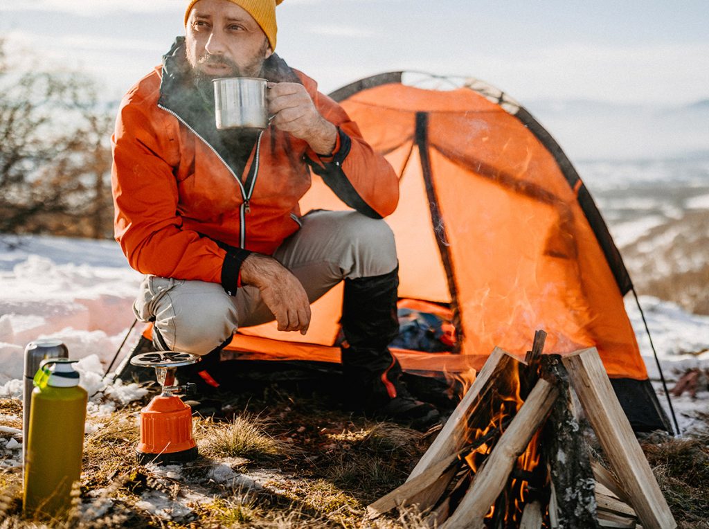 Man outdoor camping in orange jacket
