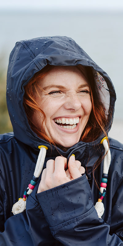 Redheaded woman in navy hooded coat smiling