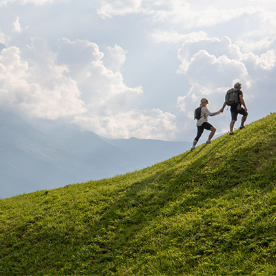 Couple climbing a majest green hill