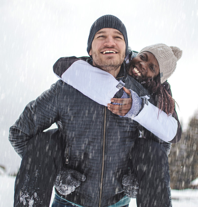 Man and woman piggy back outdoor in winter clothing